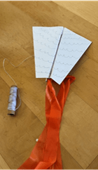 a simple kite from paper, a skewer, some string and a ribbon
